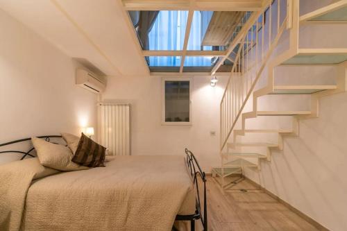 米兰[Moscova - Garibaldi] Lusso, Sauna e Idromassaggio的一间卧室设有一张床和一个楼梯