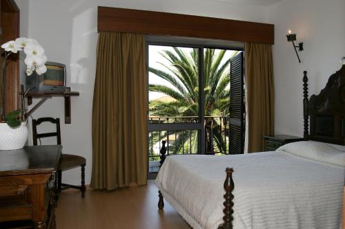 托沙阿卡达酒店的一间卧室设有一张床和一个滑动玻璃门