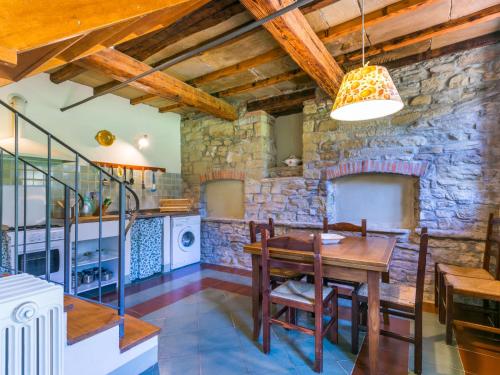 马拉迪Holiday Home Al Volo del Nibbio-2 by Interhome的厨房配有木桌和石墙