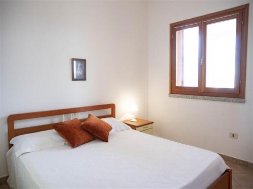 特里尼达古图Apartment Tanca Torre 60P by Interhome的一间卧室配有一张带白色床单的床和一扇窗户。