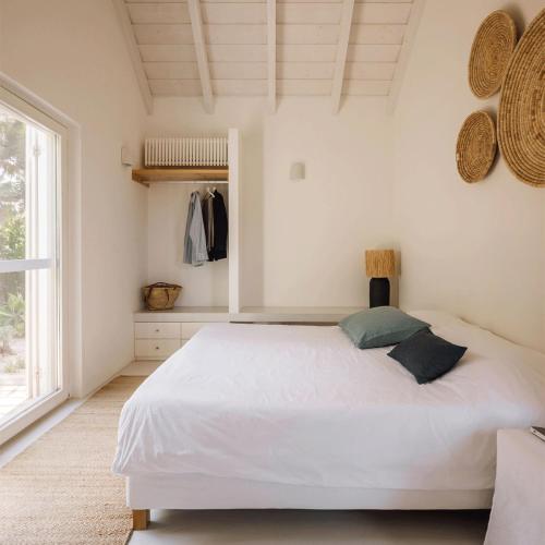 孔波尔塔Casas de Arroz的卧室配有白色的床和窗户。