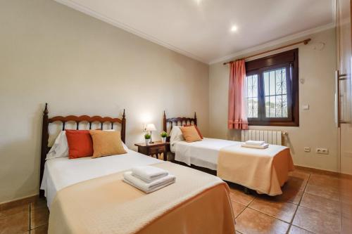 莫莱拉Villas Guzman - Fina的一间卧室设有两张床和窗户。