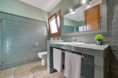 莫莱拉Villas Guzman - Fina的一间带水槽、镜子和卫生间的浴室