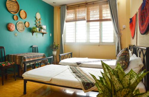 胡志明市Northern Hostel - Bui Vien Walking Street的客房设有两张床、一张桌子和一扇窗户。