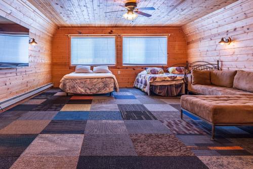 卡尔卡斯卡Lake Manistee Lodge Ski & Snowmobile Hideout的客厅配有沙发和一张位于房间的床