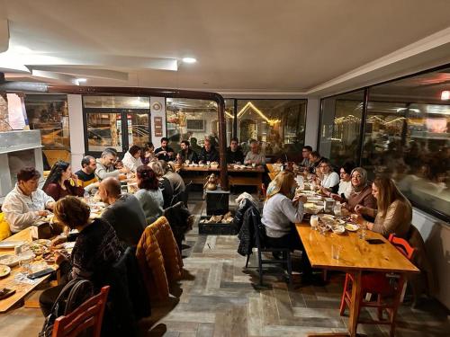 Yuvacıkyuvacik kazli bahçe bungalov & taş otel的一群坐在餐厅桌子上的人