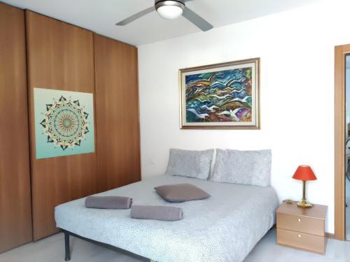 加尔达湖滨Casa Akira的卧室配有一张床,墙上挂有绘画作品