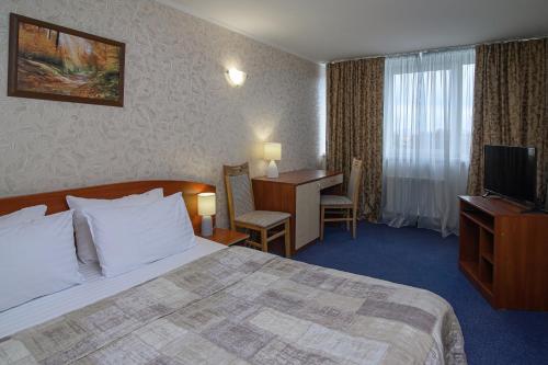 切尔卡瑟Cherkasy Palace的配有一张床和一张书桌的酒店客房