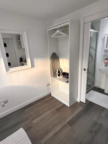 爱丁堡En-suite Room with Independent Entrance.的一间拥有白色墙壁和木地板的客房