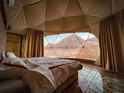 DisahLuxury tent camp的帐篷内的卧室设有大窗户