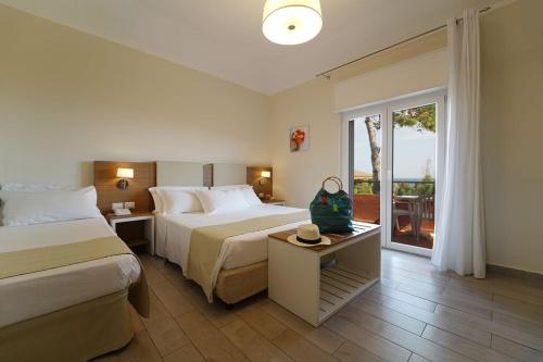 克罗托内hotel villaggio Casarossa的酒店客房设有两张床和一个阳台。