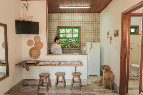 弗洛里亚诺波利斯Pousada Vila Campeche的餐桌旁的厨房,有狗