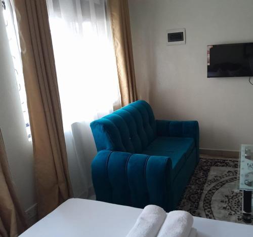 蒙巴萨Galene Abode Studio Apartment, Nyali的蓝色椅子坐在窗户的房间