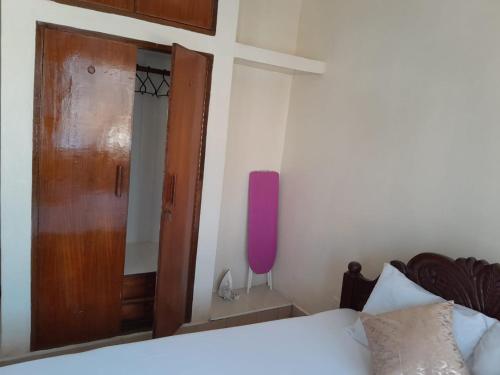 蒙巴萨Galene Abode Studio Apartment, Nyali的一间卧室配有一张床和一扇木门