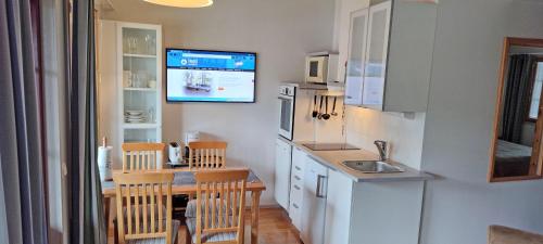 塔库沃里Apartments Tahko的厨房配有桌子,墙上配有电视。