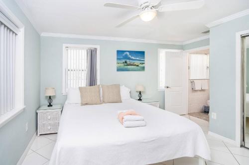 圣奥古斯丁海滩Oceans 13 Unit A的一间白色的卧室,床上有粉红色的动物