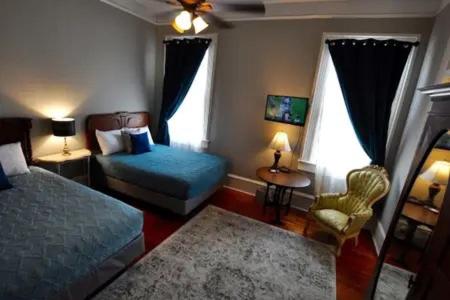 新奥尔良The Dragonfly Guest House的卧室配有床、椅子和窗户。