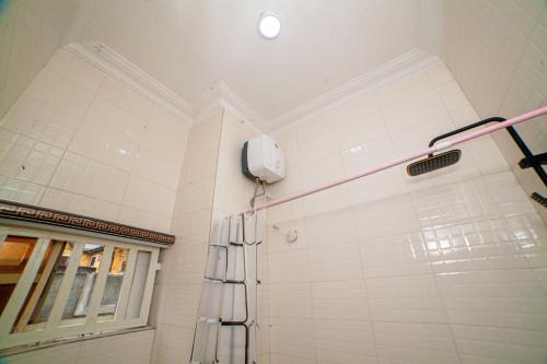 哈科特港Schemes Hotel And Apartment的浴室设有淋浴,墙上配有电话