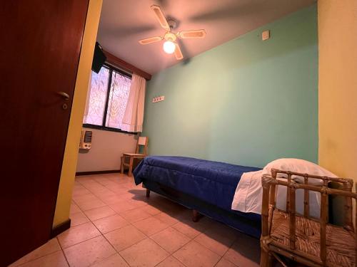圣胡安Hotel cuesta del viento II的一间卧室配有一张床和吊扇