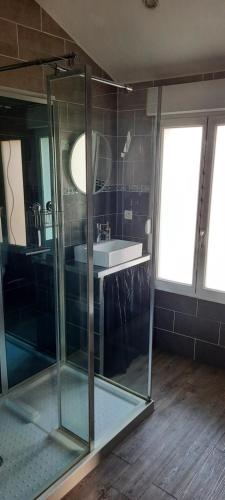 圣迪济耶charmante maison de ville的一间带玻璃淋浴和水槽的浴室