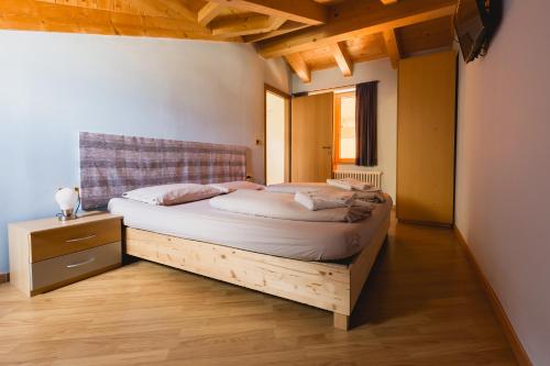 奥萨纳Bergreen Apartments的铺有木地板的客房设有一间带大床的卧室