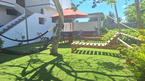 阿约拉港Galápagos Brunette Suites的花园设有吊床,庭院设有长凳