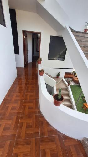 阿约拉港Galápagos Brunette Suites的房屋内的楼梯,铺有木地板,配有电视