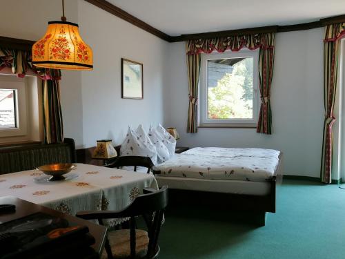 茵特斯托德Hotel garni Landhaus Bürtlmair的一间卧室设有两张床、一张桌子和一个窗口