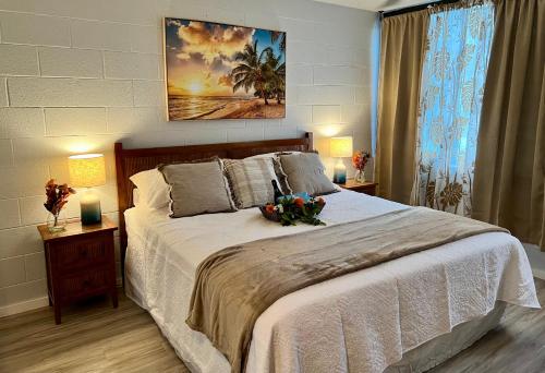 希洛Ocean view Mauna Loa Shores Kai Ekahi #201 next to Carlsmith Beach Park Hilo HI的一间卧室配有一张带两盏灯的大型白色床。