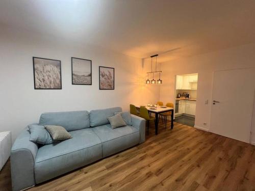 巴特罗森菲尔德BRAN: Design - Apartment Küche, Parken ,Netflix的客厅配有蓝色的沙发和桌子