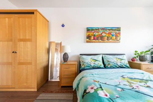 伦敦London Skylineviews 2 bed 2 bath flat near Canary Wharf, o2 & Excel的卧室配有一张床,墙上挂有绘画作品
