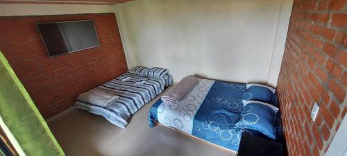 波帕扬Hostel paraiso de colores的一间小卧室,配有两张床和砖墙