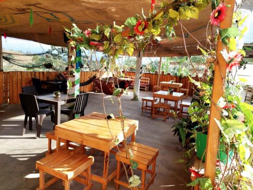 波帕扬Hostel paraiso de colores的庭院设有木桌、椅子和鲜花