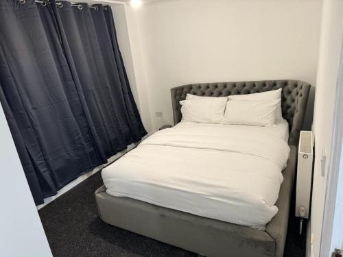 达格纳姆LUXURY APARTMENTS的一张带白色床单和枕头的床