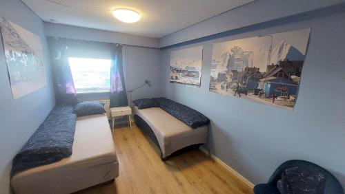 伊卢利萨特Ilulissat Apartment的小房间设有两张床和窗户