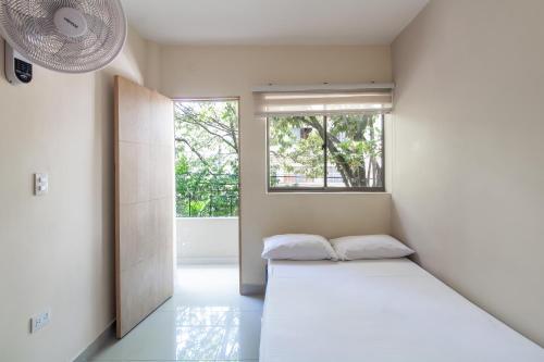 麦德林CASA TURISTICA MACHU PICCHU MEDELLIN的白色的客房设有床和窗户。