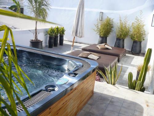 马拉喀什Riad Villa Wengé & Spa的后院的热水浴池,种植了植物