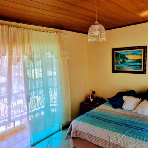里约达欧特拉斯Casa Via Sol, Rio das Ostras的一间卧室设有一张床和一个大窗户