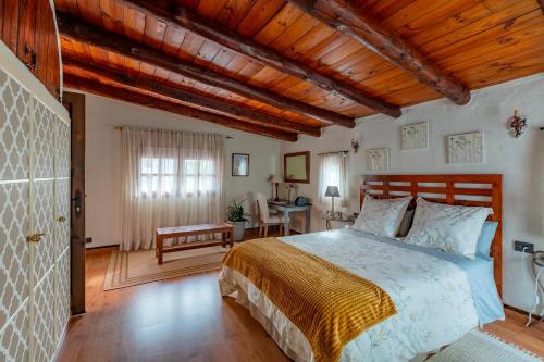 圣卢西亚Las Casas de la Rueda - El Patio的一间卧室设有一张床和木制天花板