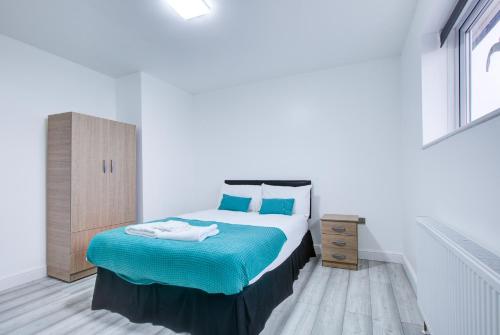 NavestockCrossVille Homes - Double rooms的一间卧室配有一张带蓝色床单和蓝色枕头的床。