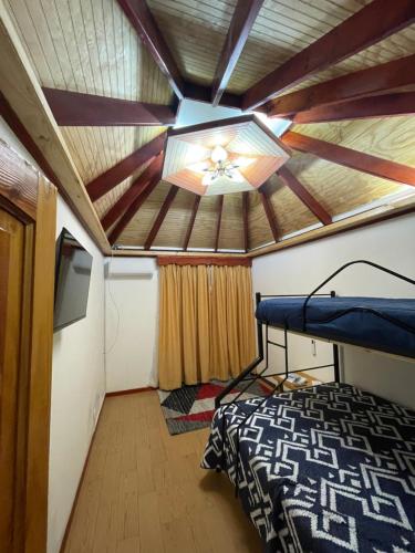 圣何塞德迈波Cabañas Los Olmos的客房设有一张床和一个吊扇。