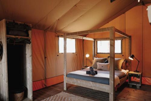 仙女港菲利港假日公园酒店的一间帐篷内带天蓬床的卧室