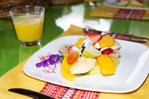 马尼萨莱斯Kairí Lodge Natural Reserve的桌上的水果盘,加上一杯橙汁