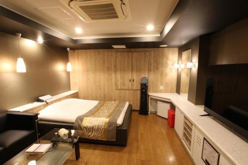 KasukabeK-WAVE的酒店客房,配有床和沙发