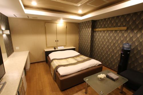 KasukabeK-WAVE的小房间设有一张床和一张桌子