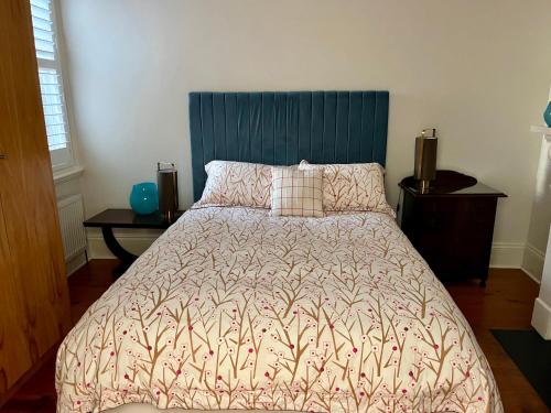 墨尔本Lovely Victorian Terrace - Entire home的一间卧室配有一张大床和蓝色床头板