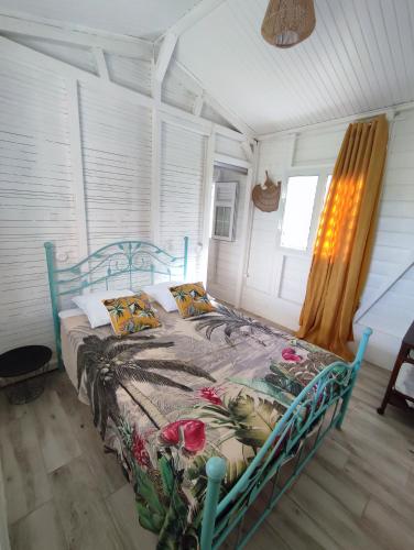 勒罗贝尔Bungalow Soleil Levant的一间卧室配有一张带鲜花的蓝色床