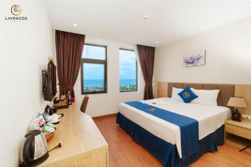 岘港Lavencos Hotel Da Nang的酒店客房设有一张大床和窗户。