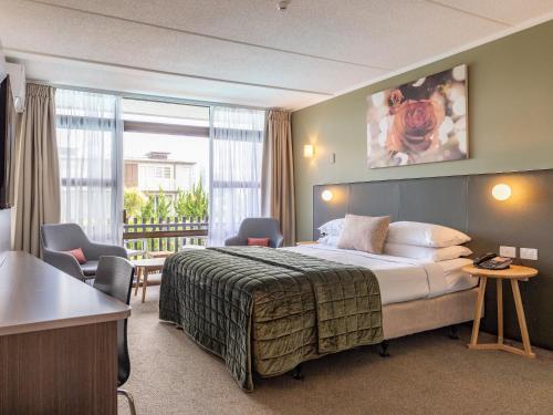 奥克兰奥克兰玫瑰园酒店的酒店客房设有一张床和一个阳台。