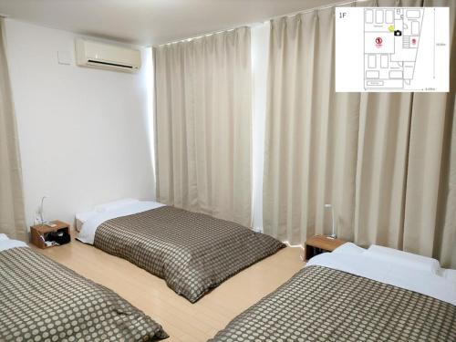 熊本Kumamoto - House - Vacation STAY 83489的一间卧室设有两张床,窗户配有窗帘